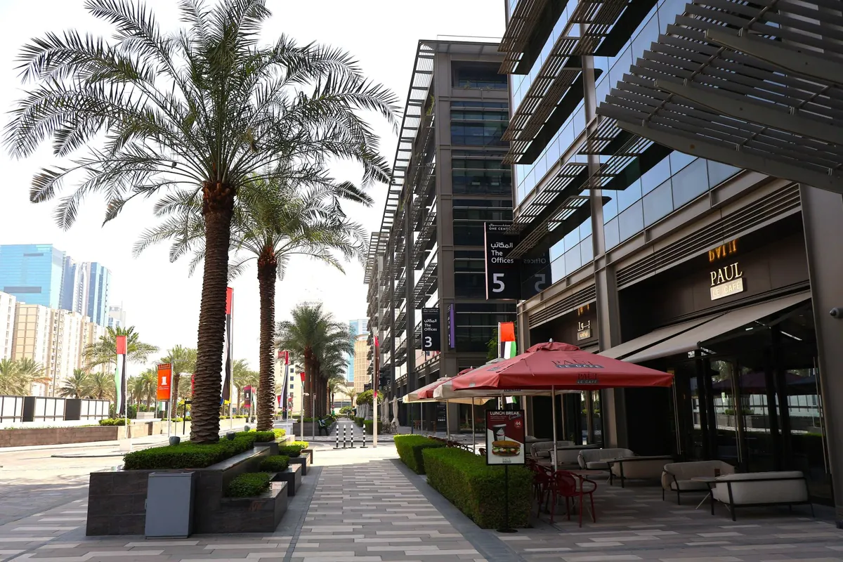 An outdoor café terrace beneath palm trees in Dubai