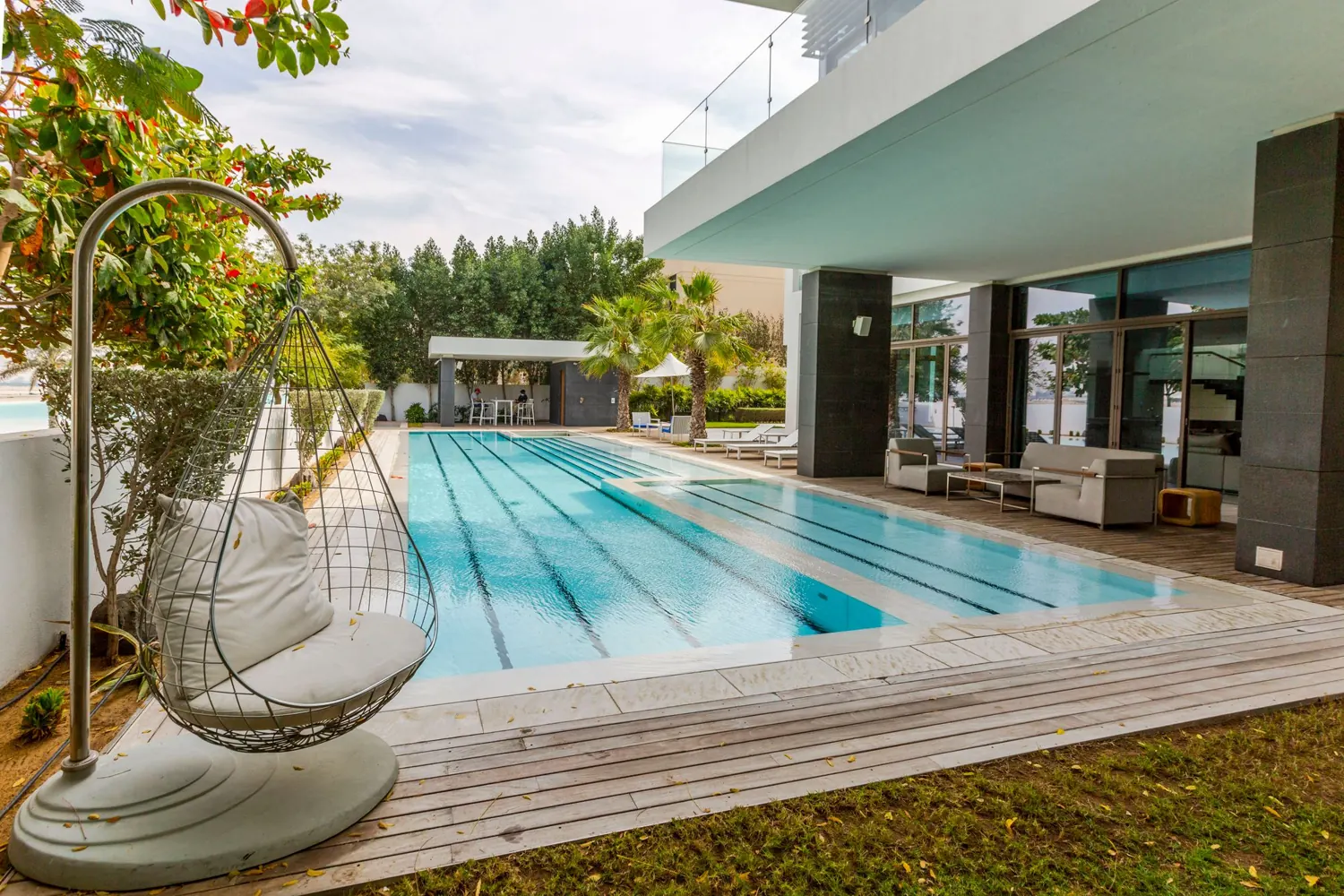 A large villa terrace beside a long pool